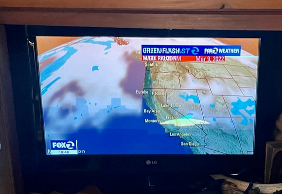 TV shot as green flash transitiosn into weather